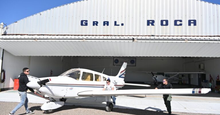Vista aérea de una aeronave del Aeroclub de General Roca en la pista, con los Valles de la Luna de fondo.