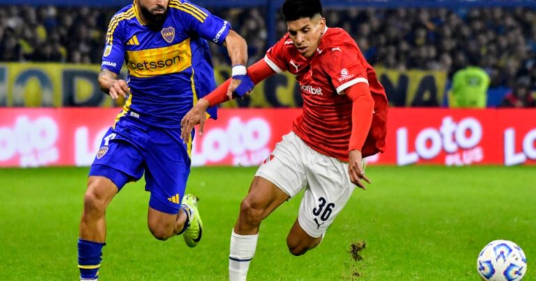 Escudos de Boca Juniors e Independiente enfrentados, con el estadio La Bombonera de fondo.