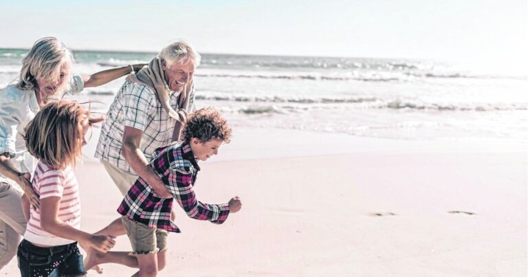 Adulto mayor utilizando una tablet con ayuda de un familiar joven, en un entorno familiar.