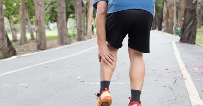 Persona mayor realizando ejercicios de fortalecimiento de piernas con una silla como apoyo.