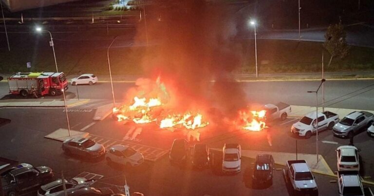 Vehículos quemados y escombros frente al edificio de la Legislatura de Neuquén tras el incendio.