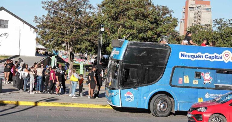 Bus turístico recorriendo un paseo costero o parque en la ciudad de Neuquén