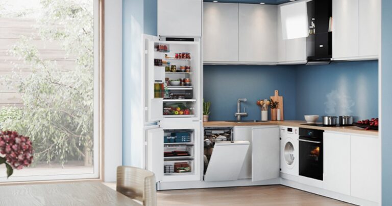 Ejemplo de una cocina moderna con muebles desayunador y columna despensa organizando el espacio.