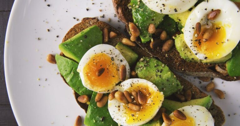 Imagen de un desayuno saludable compuesto por yogur con granola y frutas, tostadas de palta con huevo y un bowl de avena.